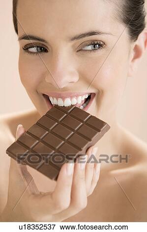 Woman eating a bar of chocolate View Large Photo Image Stock Photo - Woman eating a bar of chocolate. Fotosearch