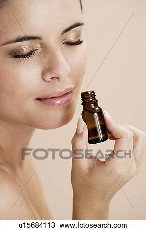 Woman smelling a bottle of essential oil View Large Photo Image Stock Image - Woman smelling a bottle of essential oil. Fotosearch