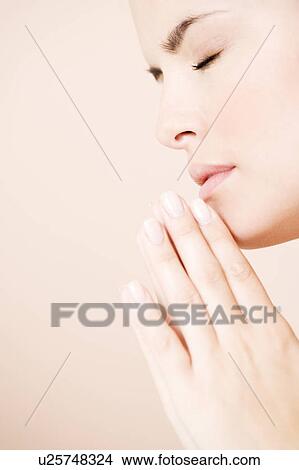 Young woman praying or meditating, hands together View Large Photo Image Picture - Young woman praying or meditating, hands together. Fotosearch