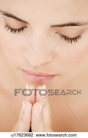 Young woman praying or meditating, hands together View Large Photo Image Stock Image - Young woman praying or meditating, hands together. Fotosearch