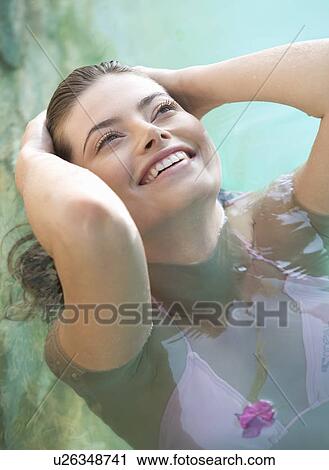 Stock Image - A woman relaxing in a pool. Fotosearch