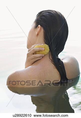 Stock Image - A woman washing with a sponge. Fotosearch