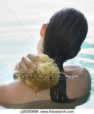 A woman washing with a sponge View Large Photo Image Stock Photo - A woman washing with a sponge. Fotosearch