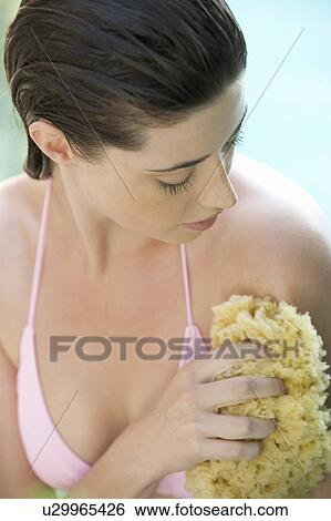 Stock Photograph - A woman washing with a sponge. Fotosearch