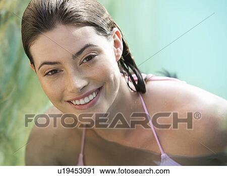 Stock Image - A woman wearing a bikini in a pool. Fotosearch