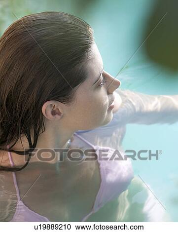 A woman wearing a bikini in a pool View Large Photo Image Stock Image - A woman wearing a bikini in a pool. Fotosearch