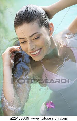 A woman wearing a bikini in a pool View Large Photo Image Stock Photo - A woman wearing a bikini in a pool. Fotosearch