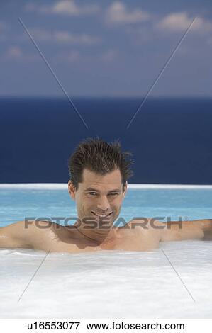Stock Photo - A man relaxing in a jacuzzi. Fotosearch