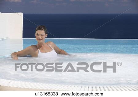 Stock Photo - A woman relaxing in a jacuzzi. Fotosearch