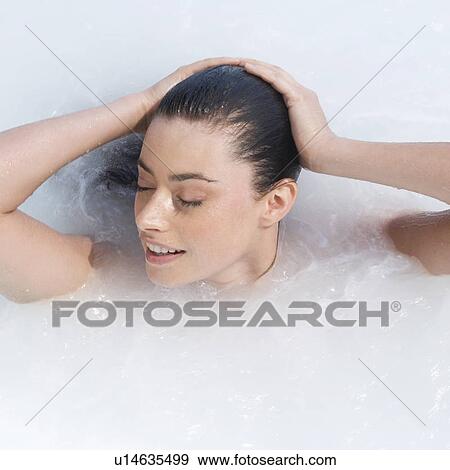 Stock Photo - A woman relaxing in a jacuzzi. Fotosearch
