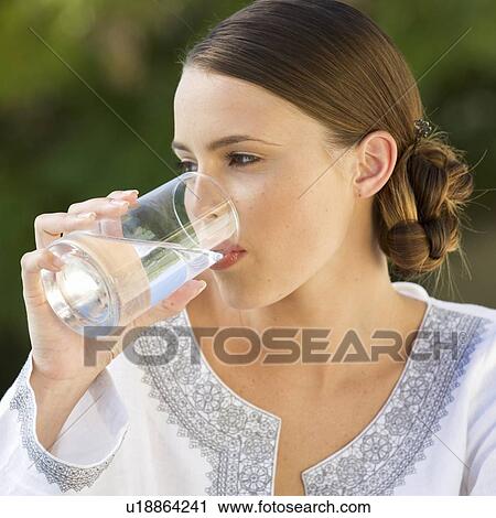 A young woman drinking a glass of water View Large Photo Image Stock Image - A young woman drinking a glass of water. Fotosearch