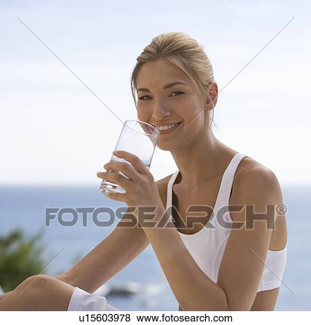 A young woman drinking a glass of water View Large Photo Image Stock Photo - A young woman drinking a glass of water. Fotosearch