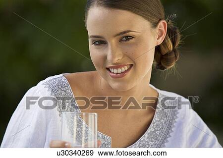 Stock Photo - A young woman drinking a glass of water. Fotosearch