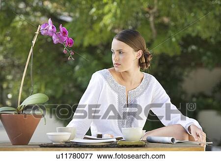 Stock Photo - A young woman eating sushi. Fotosearch