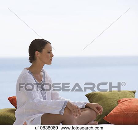 A young woman sitting on cushions View Large Photo Image Stock Photo - A young woman sitting on cushions. Fotosearch