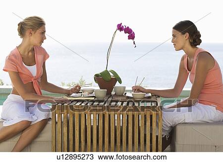 Two young women eating sushi View Large Photo Image Stock Image - Two young women eating sushi. Fotosearch
