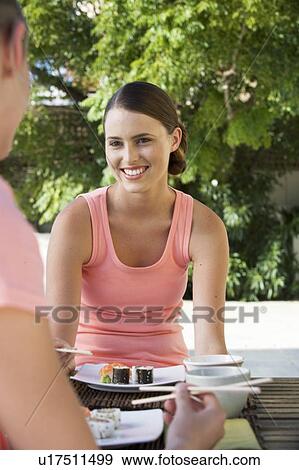 Stock Photo - Two young women eating sushi. Fotosearch