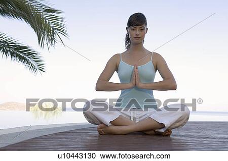 A woman meditating by a pool View Large Photo Image Stock Image - A woman meditating by a pool. Fotosearch