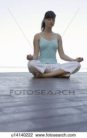 A woman meditating by a pool View Large Photo Image Stock Image - A woman meditating by a pool. Fotosearch