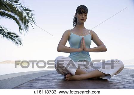 A woman meditating by a pool View Large Photo Image Stock Image - A woman meditating by a pool. Fotosearch