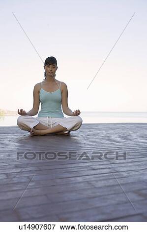A woman meditating by a pool View Large Photo Image Stock Photo - A woman meditating by a pool. Fotosearch