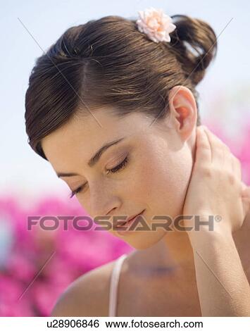 A woman rubbing her neck View Large Photo Image Stock Photograph - A woman rubbing her neck. Fotosearch