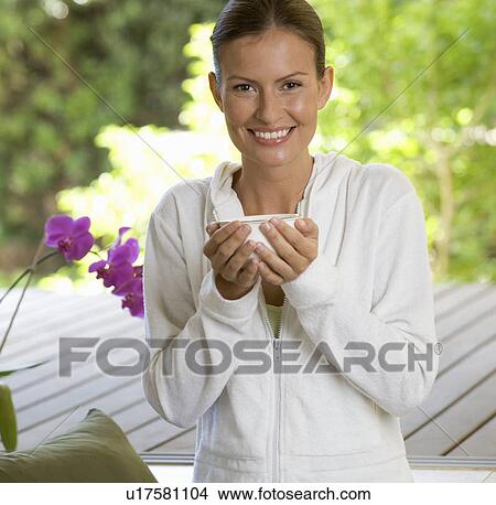 Picture - A young woman sitting in a garden. Fotosearch