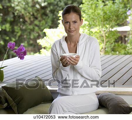 A young woman sitting in a garden View Large Photo Image Stock Image - A young woman sitting in a garden. Fotosearch