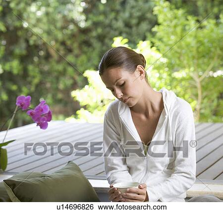 A young woman sitting in a garden View Large Photo Image Stock Photograph - A young woman sitting in a garden. Fotosearch