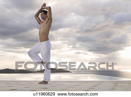 A man doing yoga by a pool View Large Photo Image Stock Photo - A man doing yoga by a pool. Fotosearch