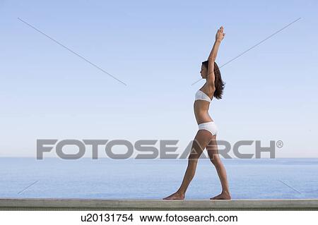 Picture - A young woman practicing yoga. Fotosearch