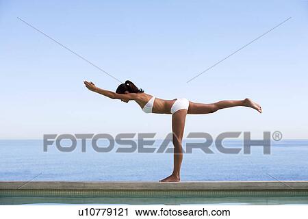 A young woman practicing yoga View Large Photo Image Stock Image - A young woman practicing yoga. Fotosearch