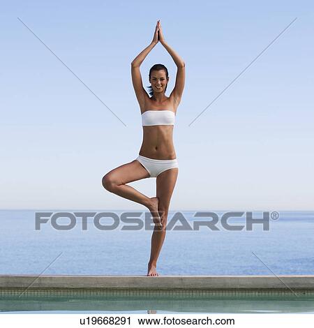 Stock Image - A young woman practicing yoga. Fotosearch