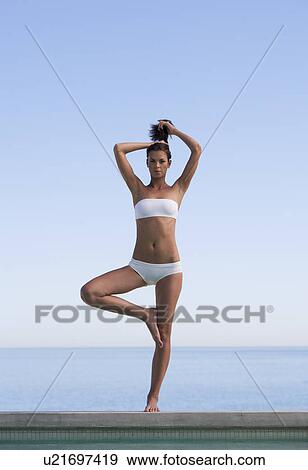 Stock Photo - A young woman practicing yoga. Fotosearch
