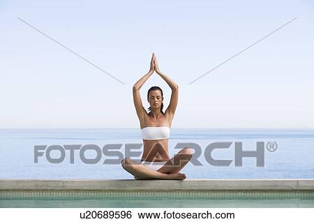 Stock Photograph - A young woman practicing yoga. Fotosearch