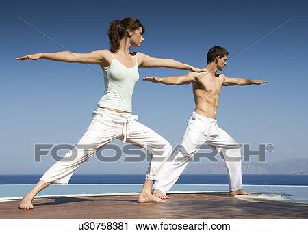 Stock Image - Two people exercising by a pool. Fotosearch