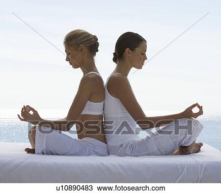 Two young women practicing yoga View Large Photo Image Stock Image - Two young women practicing yoga. Fotosearch