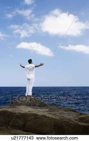 Stock Image - A man meditating by the sea. Fotosearch