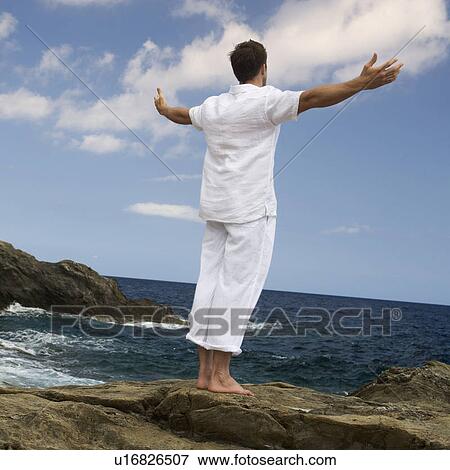 Stock Photo - A man meditating by the sea. Fotosearch