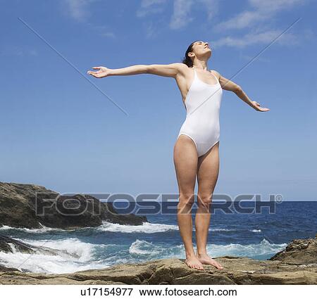 Stock Photo - A woman meditating by the sea. Fotosearch