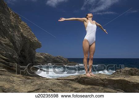 Stock Photo - A woman meditating by the sean. Fotosearch