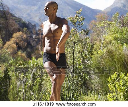 Stock Photo - Bare chested young man practicing yoga . Fotosearch