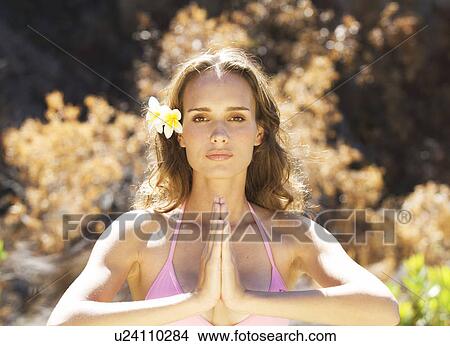 Picture - Young woman in a bikini practicing yoga. Fotosearch