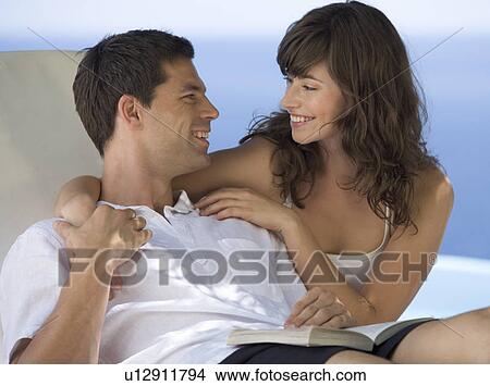 A couple relaxing by a pool View Large Photo Image Picture - A couple relaxing by a pool. Fotosearch