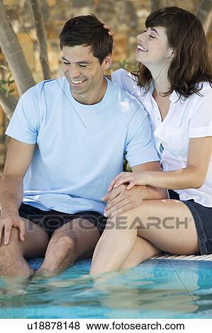 A couple relaxing by a pool View Large Photo Image Stock Photo - A couple relaxing by a pool. Fotosearch