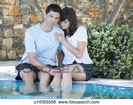 A couple relaxing by a pool View Large Photo Image Stock Photograph - A couple relaxing by a pool. Fotosearch