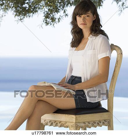 Stock Image - A woman reading by a pool. Fotosearch