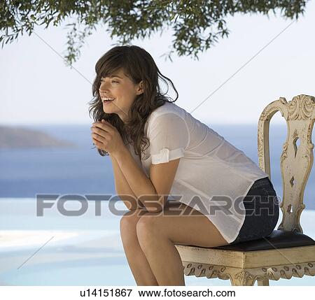 Stock Photo - A woman relaxing by a pool. Fotosearch