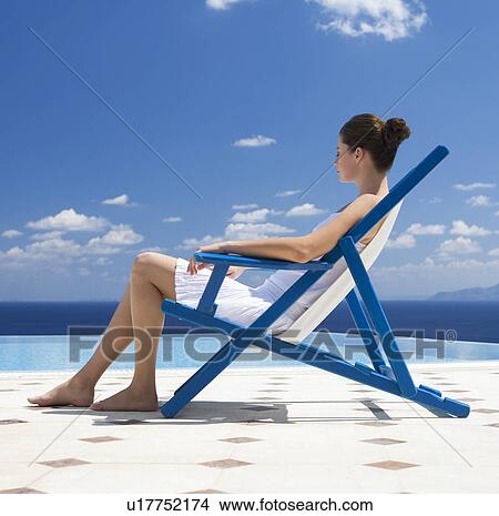 A woman relaxing in a deck chair View Large Photo Image Picture - A woman relaxing in a deck chair. Fotosearch