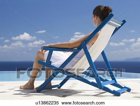A woman relaxing in a deck chair View Large Photo Image Stock Photography - A woman relaxing in a deck chair. Fotosearch